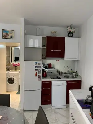 a kitchen with white cabinets and a white refrigerator at Cannes Apartment close to Congress Palace, Croisette, Beaches in Cannes