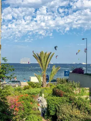 a beach with kites flying over the ocean at Cannes - Beachfront with private garden - Palm Beach Croisette in Cannes