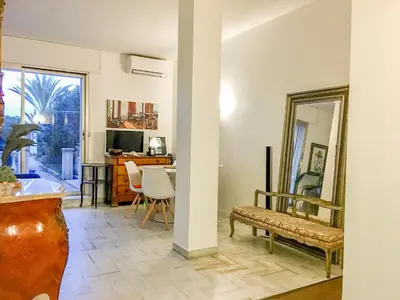 a living room with a mirror and a table at Cannes - Beachfront with private garden - Palm Beach Croisette in Cannes