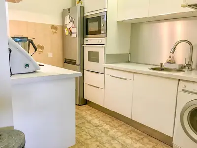 a kitchen with a sink and a refrigerator at Cannes - Beachfront with private garden - Palm Beach Croisette in Cannes