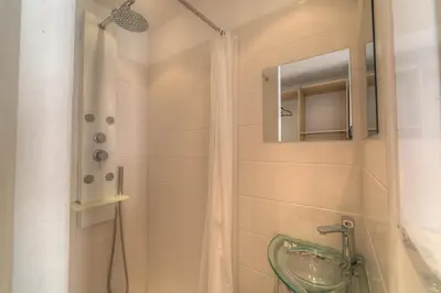 a bathroom with a shower with a sink and a mirror at IMMOGROOM - Beautiful duplex - Sea view - Quiet - AC - Wifi - Garage in Cannes