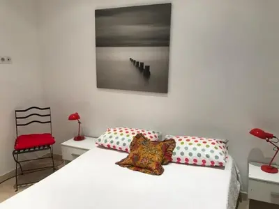 a bedroom with a white bed with two pillows and a chair at Alouette in Cannes