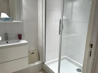 a white bathroom with a shower and a sink at Alouette in Cannes