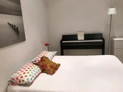 a bedroom with a white bed with pillows and a piano at Alouette in Cannes