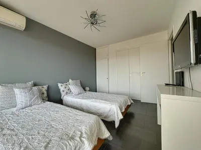 a bedroom with two beds and a tv on the wall at AGENCIA appartement 2 chambres au Suquet in Cannes