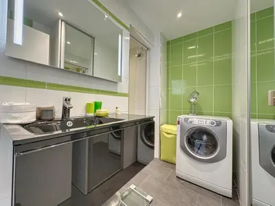 a bathroom with a sink and a washing machine at AGENCIA appartement 2 chambres au Suquet in Cannes