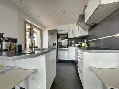 a kitchen with white cabinets and a black counter top at AGENCIA appartement 2 chambres au Suquet in Cannes