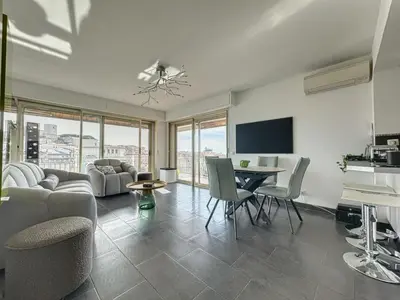 a living room with a couch and a table with chairs at AGENCIA appartement 2 chambres au Suquet in Cannes