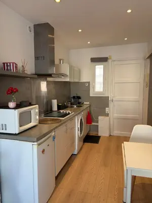 a kitchen with a washing machine and a table at Appartement Palais des Festivals in Cannes