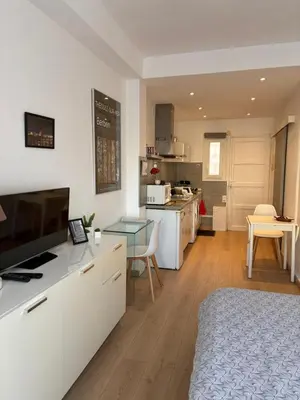 a kitchen with a table and a white table and a laundry room at Appartement Palais des Festivals in Cannes