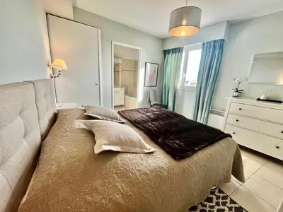a bedroom with a bed with pillows and a mirror at Bristol by Welcome to Cannes in Cannes