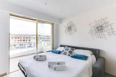 a bedroom with a bed with a large window at IMMOGROOM - Renovated apartment - Terrace - AC - Wifi in Cannes