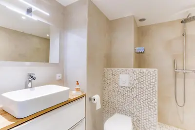 a white bathroom with a sink and a shower at IMMOGROOM - Renovated apartment - Terrace - AC - Wifi in Cannes