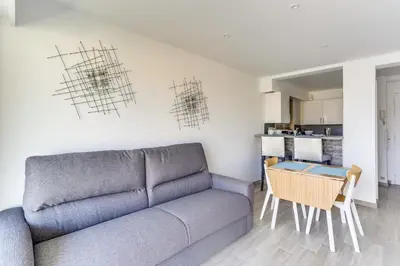 a living room with a couch and a table at IMMOGROOM - Renovated apartment - Terrace - AC - Wifi in Cannes