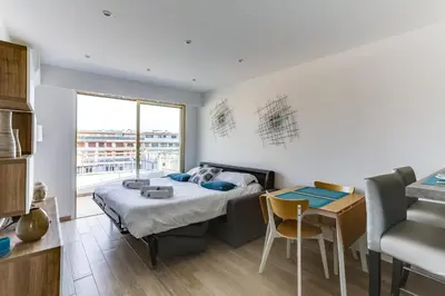 a bedroom with a bed and a desk and a table at IMMOGROOM - Renovated apartment - Terrace - AC - Wifi in Cannes