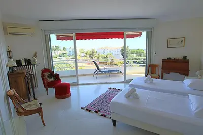 a bedroom with two beds and a view of a balcony at Fully equipped appartment 105 m2 clear view on the sea and californie hills in Cannes