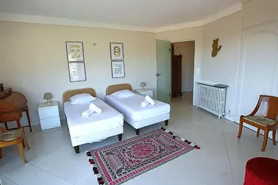 two beds in a room with a rug at Fully equipped appartment 105 m2 clear view on the sea and californie hills in Cannes