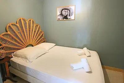 a bed with two towels and a picture of a man at Fully equipped appartment 105 m2 clear view on the sea and californie hills in Cannes