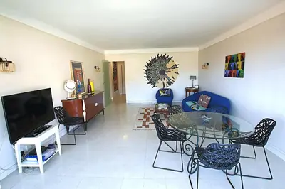 a living room with a blue couch and a glass table at Fully equipped appartment 105 m2 clear view on the sea and californie hills in Cannes