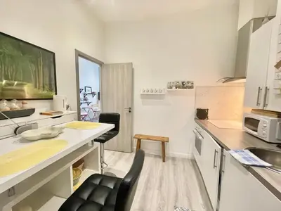 a kitchen with a desk and chairs in a room at Casa Valfa à 200m du Palais, by Welcome to Cannes in Cannes