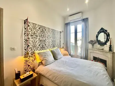 a bedroom with a bed with a headboard and a fireplace at Casa Valfa à 200m du Palais, by Welcome to Cannes in Cannes