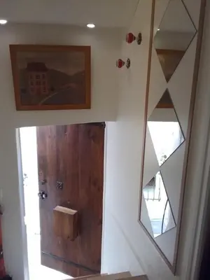 a bathroom with a wooden door and a mirror at Studio à 2 pas du Palais in Cannes