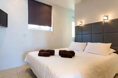 a bedroom with a large white bed with two brown towels at Cannes Vieux Port in Cannes
