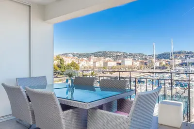 a dining room with a table and chairs on a balcony at Cannes Vieux Port in Cannes