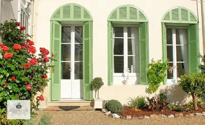 a house with green shuttered windows and flowers at 'Maison Blanche' in Cannes