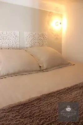 a bedroom with a bed with a light on the wall at 'Maison Blanche' in Cannes