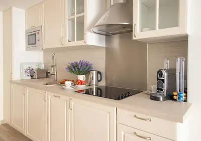 a kitchen with white cabinets and a black counter top at Cannes Imperial Croisette Palais Miramar in Cannes