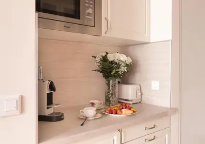 a kitchen counter with a plate of fruit and a vase of flowers at Cannes Imperial Croisette Palais Miramar in Cannes