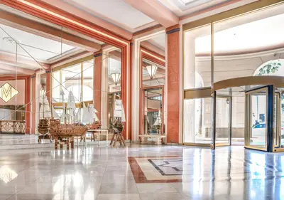 a large lobby with glass windows and a piano at Cannes Imperial Croisette Palais Miramar in Cannes