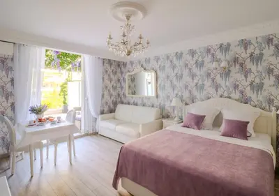 a bedroom with a bed and a couch and a table at Cannes Imperial Croisette Palais Miramar in Cannes