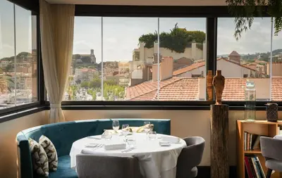 a table in a room with a large window at Five Seas by Inwood Hotels in Cannes