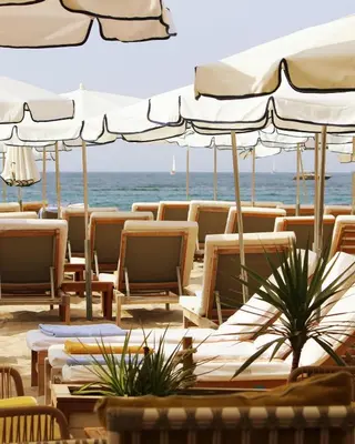 a group of chairs and umbrellas on the beach at Five Seas by Inwood Hotels in Cannes