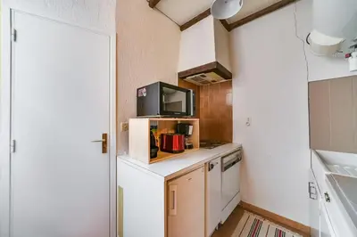 a kitchen with a tv on a counter with a microwave at IMMOGROOM- Close to the Palais des festivals- Wifi in Cannes
