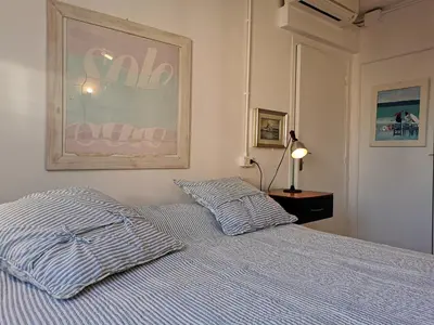 a bedroom with a bed with a striped comforter at Karol in Cannes