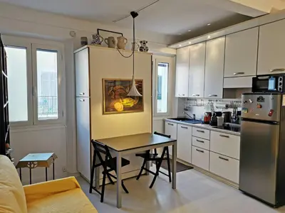 a kitchen with white cabinets and a table in it at Karol in Cannes