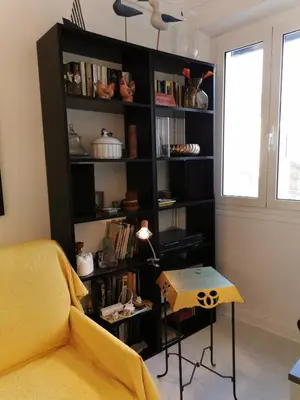 a black book shelf with a table in a room at Karol in Cannes