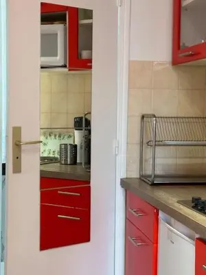 a kitchen with red cabinets and a microwave at Mark in Cannes