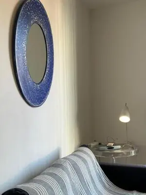 a blue mirror hanging on a wall with a couch at Mark in Cannes