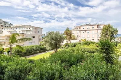 a view of a garden with buildings in the background at Welcoming Apartment with parking - Croisette in Cannes