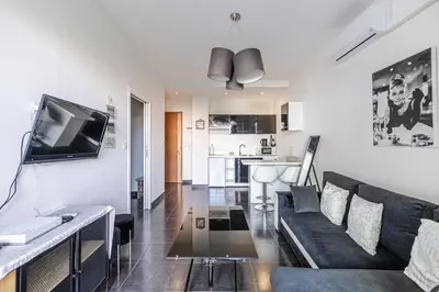 a living room with a couch and a tv at Welcoming Apartment with parking - Croisette in Cannes
