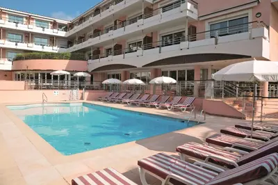 a swimming pool with lounge chairs and a hotel at Zenitude Hôtel-Résidences Le Cannet in Le Cannet