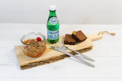 a bottle of soda sitting next to a cutting board with food at Zenitude Hôtel-Résidences Le Cannet in Le Cannet