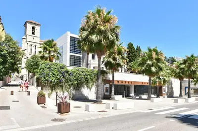 a street with palm trees and a building at Zenitude Hôtel-Résidences Le Cannet in Le Cannet