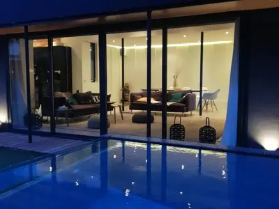 a house with a swimming pool and a living room at Villa Le Ruisseau in Cannes