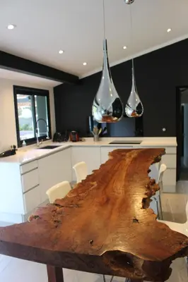 a kitchen with a wooden table with chairs and lights at Villa Le Ruisseau in Cannes