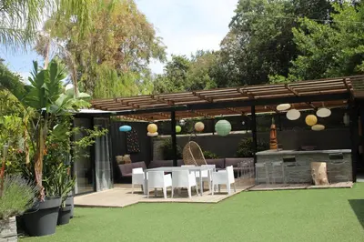 a patio with a table and chairs on a lawn at Villa Le Ruisseau in Cannes